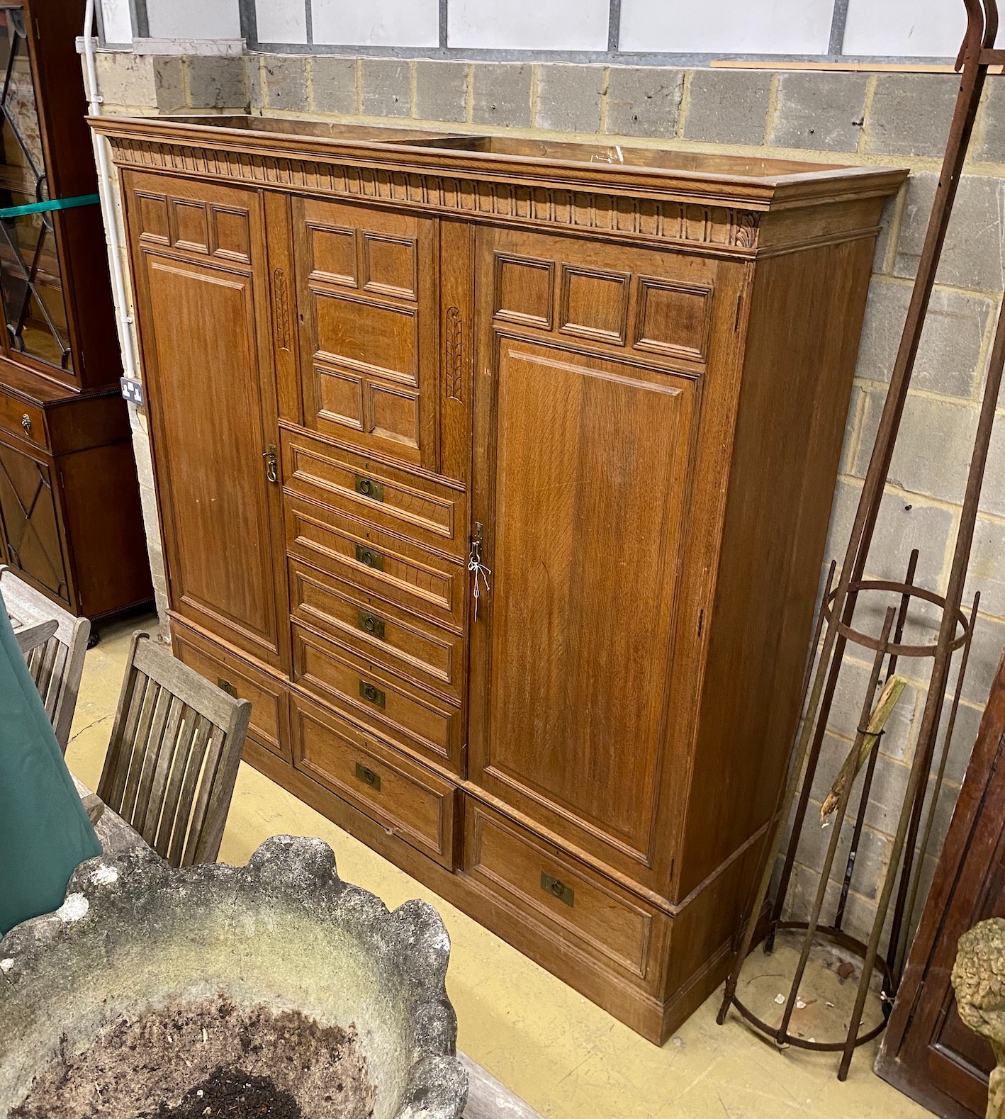 A late 19th century German Art Nouveau oak compactum wardrobe, length 224cm, depth 56cm, height 204cm